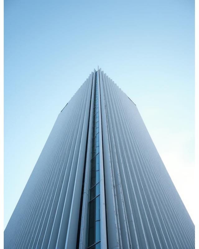 Striking modern building facade with geometric patterns against a clear sky